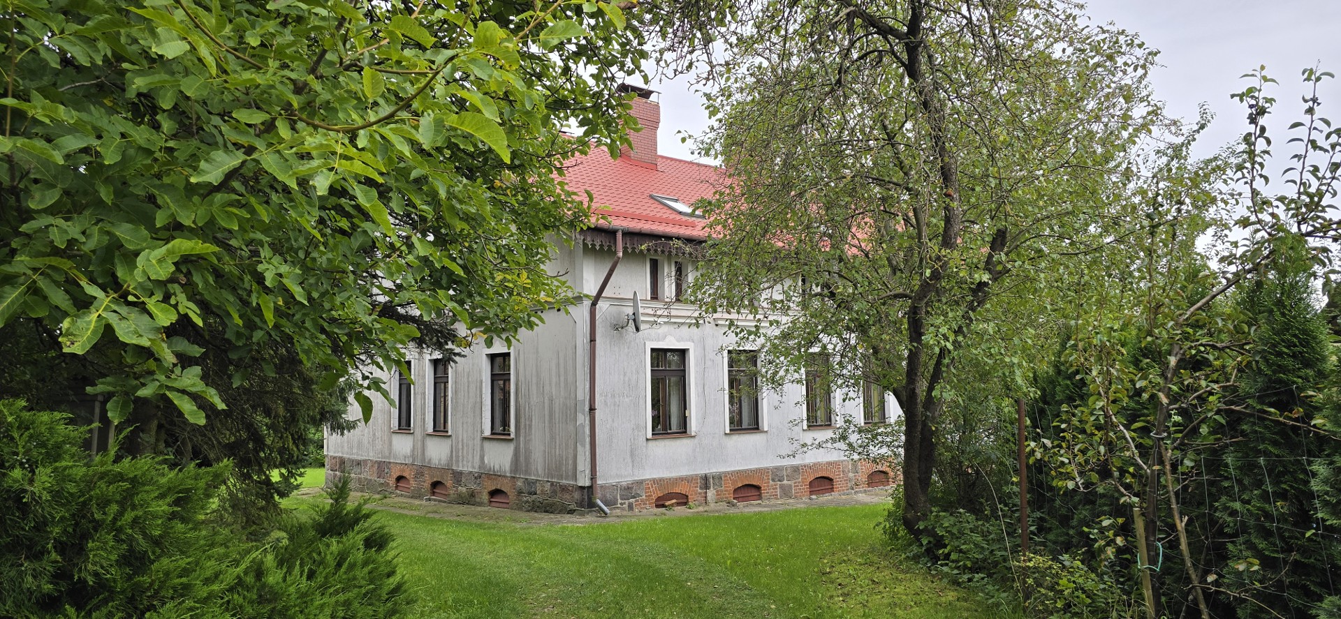 Poniemiecka posiadłość ze stajnia, zabudowaniami gospodarczymi i stawem.