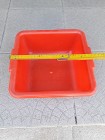 Czerwony plastikowy pojemnik, kwadratowy o boku ok. 25 cm, ok. 10 cm głębokości