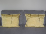 Dwie pasujące do siebie poszewki na poduszki w kolorze złotym